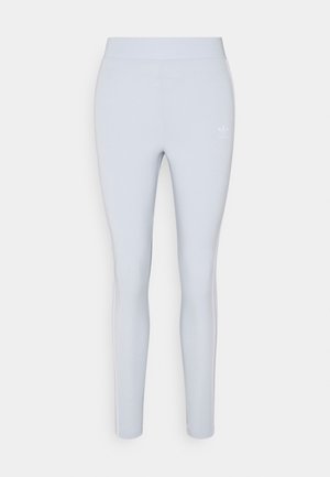 Leggings de color azul claro, confeccionados con un material elástico, que presentan una textura suave y un pequeño logo blanco cerca de la cinturilla. Corte ajustado.