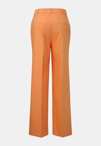 Weite Hosen aus einem lebhaften orangefarbenen Stoff. Sie haben eine glatte Textur, aufgesetzte Taschen und einen taillierten Bund für eine bequeme Passform.