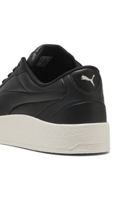 Czarne skórzane trampki Puma z białą teksturowaną podeszwą i logo Puma na pięcie, pokazane pod kątem z tyłu na białym tle.