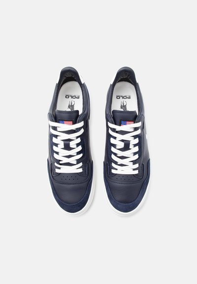 Tmavě modré kožené tenisky s bílými tkaničkami, bílými podrážkami, americkou vlajkou na jazyku a logem Polo Ralph Lauren uvnitř.