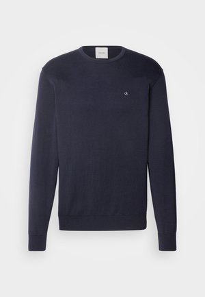 Maglione lavorato a maglia blu navy con maniche lunghe, colletto rotondo e piccolo logo bianco sul petto. Texture liscia e polsini e orlo a coste.