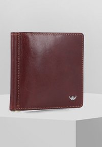Portafoglio in pelle marrone con una superficie liscia, design a due pieghe e cuciture in contrasto. Presenta un piccolo emblema del logo argentato.