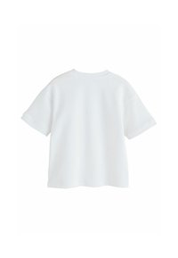 Hvid bomulds T-shirt med rund halsudskæring, korte ærmer og en afslappet pasform. Tekstureret materiale med en glat overflade og ingen synlige mønstre.