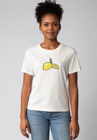 Witte katoenen t-shirt met een grafisch ontwerp van een hele citroen en een citroenschijfje met groene bladeren, korte mouwen en een ronde hals.