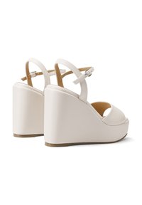 Sandali in una finitura liscia di colore bianco, con design open toe, cinturino alla caviglia regolabile e tacco spesso e sagomato per un'altezza aggiuntiva.