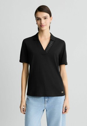 Polo shirt nero con scollatura a V e pannello testurizzato sul colletto. Maniche corte, tessuto morbido e dettaglio del logo dorato all'orlo.