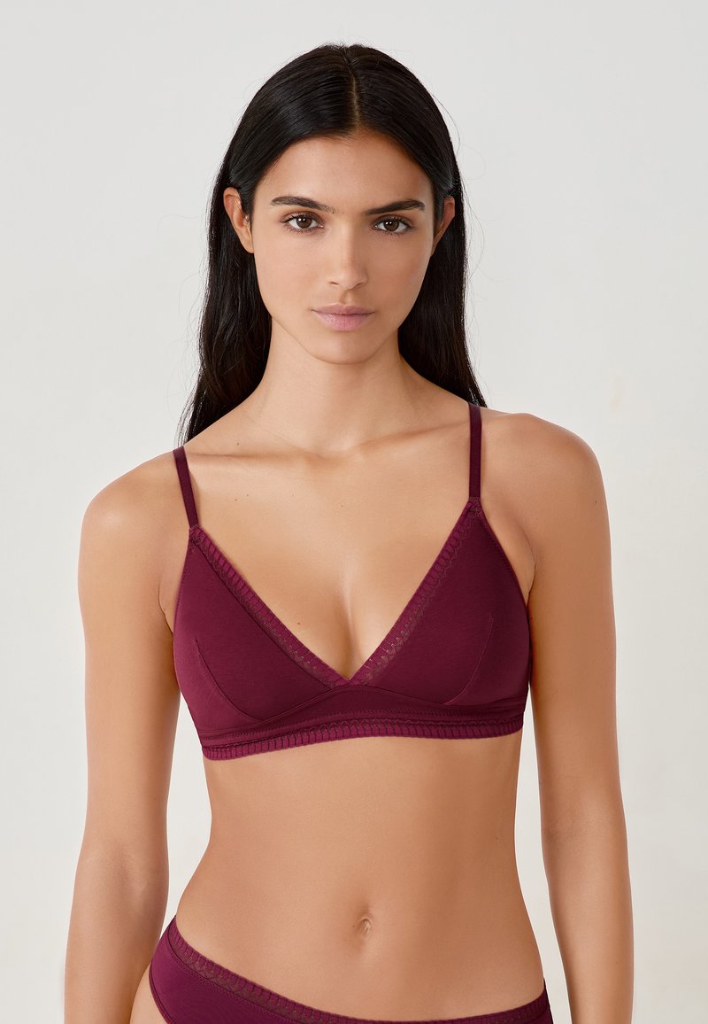 Brassière bordeaux en forme de triangle, avec des fines bretelles réglables et une bordure en dentelle le long du col et de la bande, fabriquée en tissu doux.