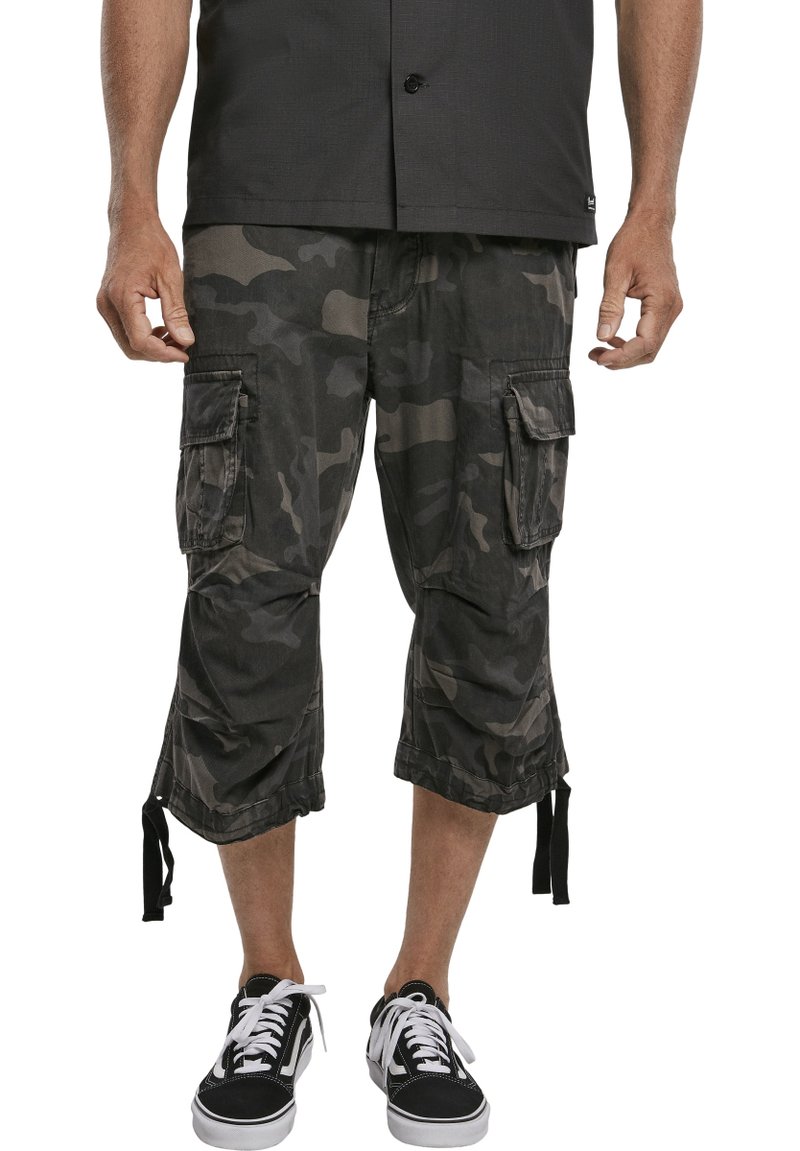 Sötét kamuflázs mintás cargo short, tartós anyagból készült, több zsebével és állítható kötőfékével az alján.