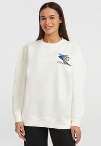 Sudadera blanca con cuello redondo, hombros caídos y puños acanalados. Presenta un diseño gráfico en azul y rojo en la zona del pecho izquierdo.