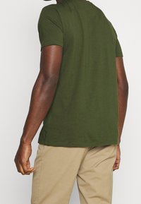 Olivenfarvet kortærmet T-shirt lavet af bomuld, med rund halsudskæring, lige skæring og glat tekstur. Ingen synlige mønstre eller accenter.