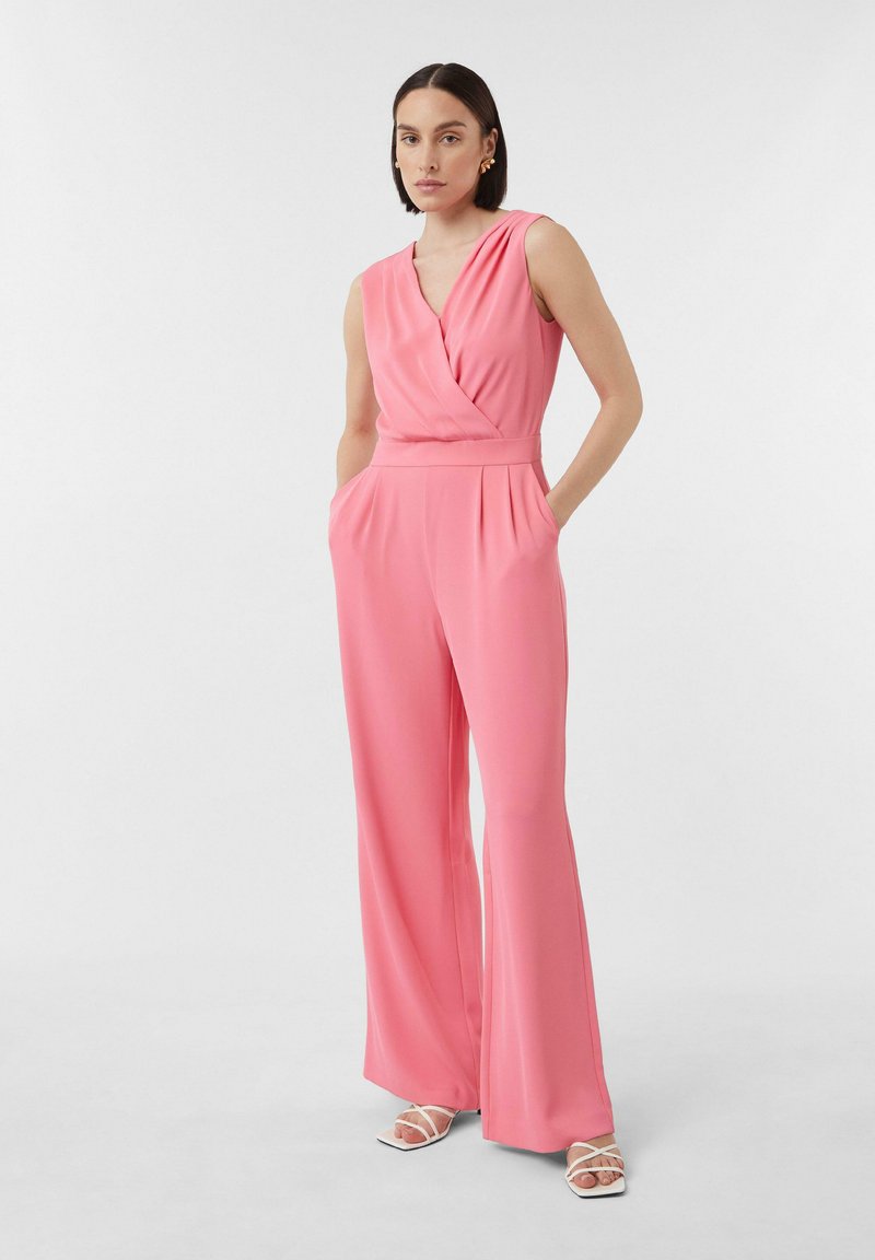 Roze mouwloze jumpsuit met een wikkelvoorkant, gestructureerde taille en wijde broekspijpen, voorzien van zijzakken en een soepele stoftextuur.