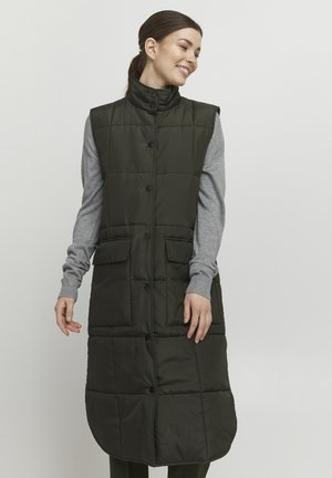 Gilet imbottito senza maniche di colore verde scuro con colletto alto, bottoni a scatto frontali e due grandi tasche anteriori, indossato sopra un top grigio a maniche lunghe.