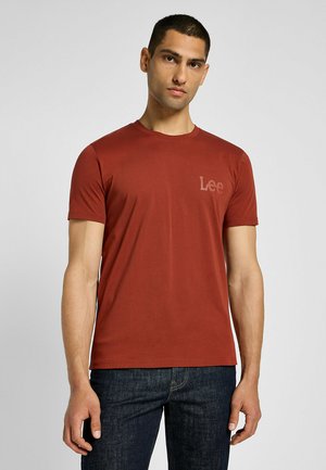 T-shirt di cotone rosso con maniche corte, scollatura rotonda e logo "Lee" stampato in un colore sobrio, abbinato a jeans di denim scuro.