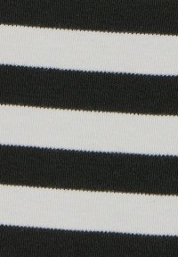 Tkanina w czarno-białe paski, z naprzemiennie szerokimi i wąskimi pasami, o gładkiej fakturze i widocznych detalach szwów.