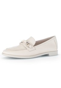 Beige leather loafers with a rounded toe, featuring a decorative strap and circular metal accent, on a low, flat sole.