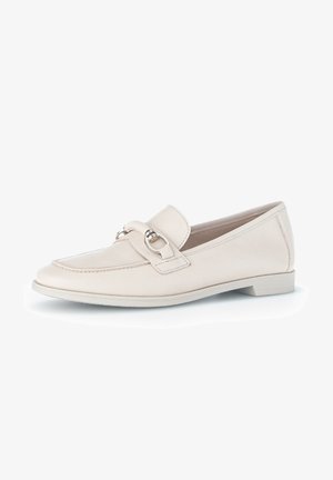 Beige Leder Slipper mit runder Spitze, ausgestattet mit einem dekorativen Riemen und einem runden Metallelement, auf einer niedrigen, flachen Sohle.