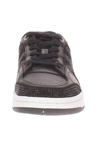 Scarpa atletica nera con tomaia in pelle perforata, design con lacci, linguetta imbottita e suola in gomma bianca. Presenta dettagli sagomati lungo i lati.