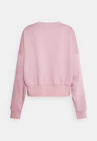 Klippt sweatshirt i ljus rosa, tillverkad av mjukt tyg. Har långa ärmar, ribbade muddar och en enkel, ren design utan mönster.