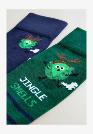 Para skarpetek; jedna granatowa z postacią i rogami, druga zielona z postacią, napisem "JINGLE SMELLS" oraz białymi akcentami. Miękka dzianinowa tekstura.