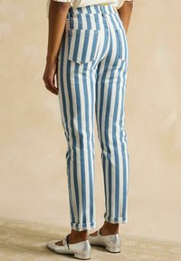 Randiga jeans i denim med ljusblå och vita vertikala ränder, en figurnära passform och uppvikta muddar, med två bakfickor.