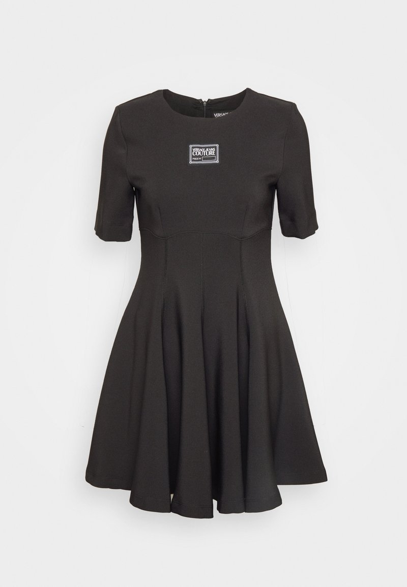 Black short-sleeve dress with fitted bodice and flared skirt. Features a zipper at the back and a label on the chest. Smooth texture.