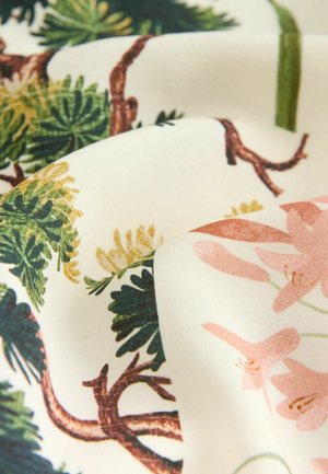 Fabric with floral and foliage patterns in green, pink, and yellow on a cream background, showcasing smooth texture and detailed designs.