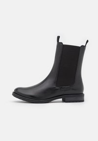 Stivale Chelsea in pelle nera con pannelli laterali elastici, linguette anteriori e posteriori e tacco basso impilato.