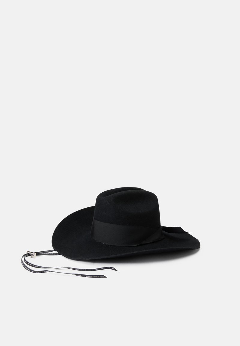 Črn filčast klobuk s širokim robom, okrašen z satensko trakom in dvema dolgima trakoma. Ima gladko teksturo in klasično obliko.