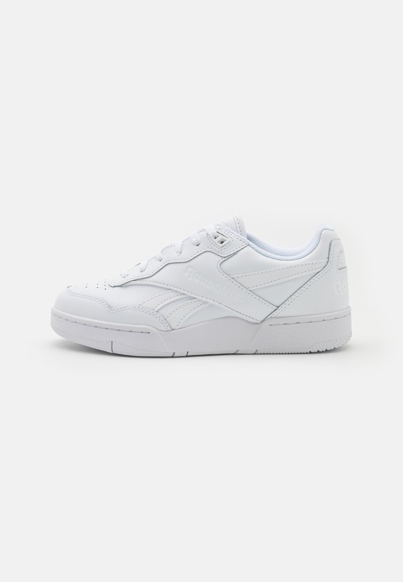 Baskets basses blanches avec fermeture à lacets, semelle texturée et marquage subtil Reebok sur le côté et le talon, vues de profil.