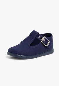 Scarpa in tela blu navy con punta tonda, lati in cut-out e chiusura anteriore con fibbia. Suola in gomma piatta e dettagli di cucitura minimi.