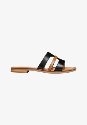 Sandalo piatto con cinturini in pelle nera e marrone e suola color cuoio, progettato per un uso casual.