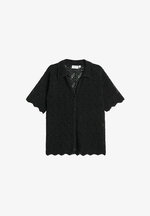 Chemise noire à manches courtes en tissu en maille ajourée présentant un motif géométrique, un boutonnage devant et un ourlet festonné.
