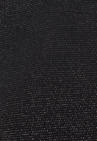 Svart tyg med en texturerad, ribbad yta, som har små metalliska prickar som tillför en subtil glans.