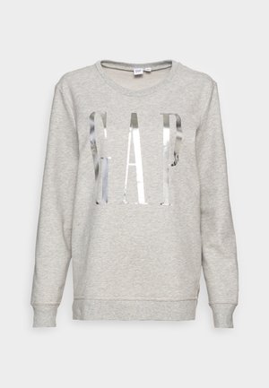 Jasnoszara bluza z długim rękawem, okrągłym dekoltem i dużym metalicznym srebrnym logo „GAP” umieszczonym na środku przodu.