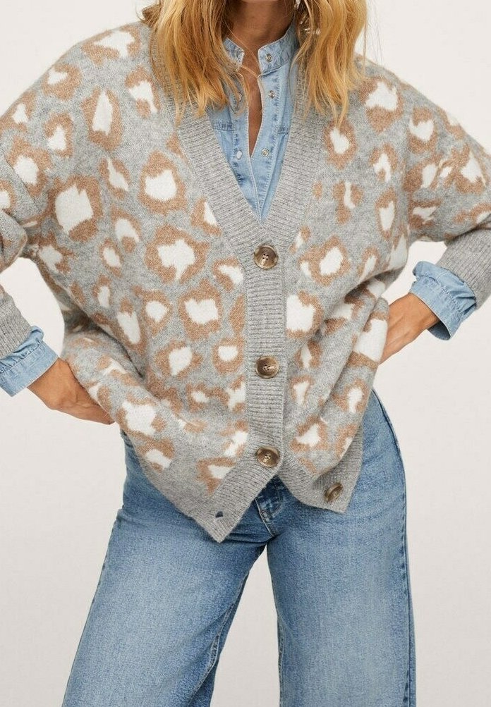 Cardigan grigio chiaro con stampa leopardata marrone e bianca, caratterizzato da grandi bottoni e una vestibilità comoda. Tessuto leggero e morbido.