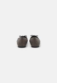 Braune, gemusterte Ballerinas mit schwarzen Akzenten, runder Zehenform und kleinem Schleifendetail hinten. Hergestellt aus einem Stoff mit glatter Textur.