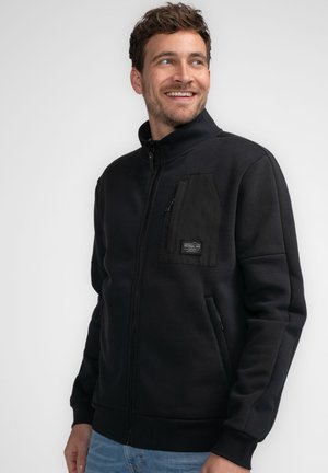 Black zip-up jacket with a high collar, featuring a textured pocket on the chest, side pockets, and ribbed cuffs and hem.