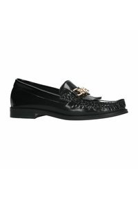 Zwarte leren loafers met een franjes ontwerp en gouden kettingaccent op de bovenkant. Rond neus en platte hak. Gladde textuur overal.