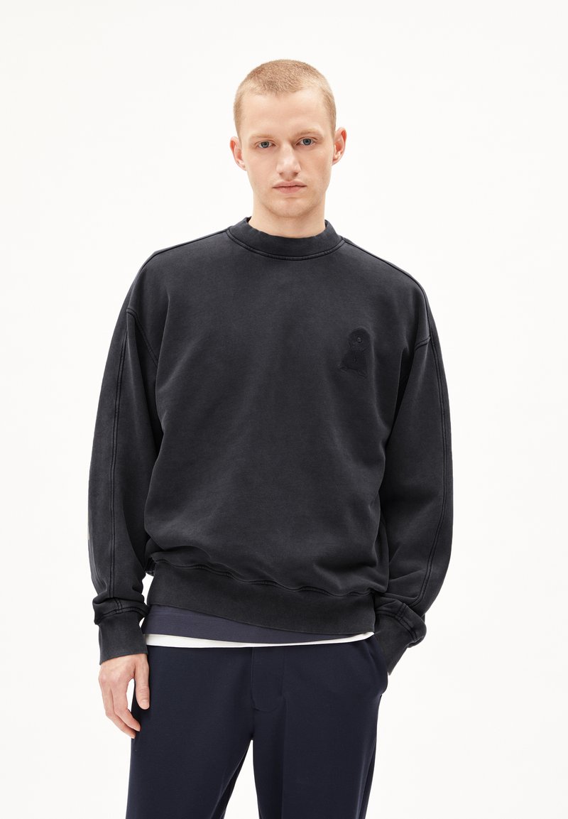 Black sweatshirt made of cotton blend, featuring a crew neck, ribbed cuffs, and an embossed logo on the left chest. Smooth texture.