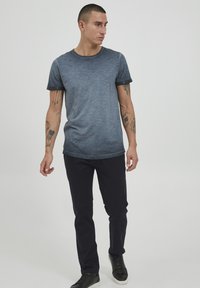 Tricou pentru bărbați cu mânecă scurtă de culoare albastru închis, cu gradient de albastru deschis, guler rotund, asortat cu pantaloni negri slim-fit și adidași negri.