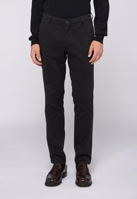 Černé slim-fit kalhoty vyrobené z bavlněné směsové tkaniny. Mají přední zip, zapínání na knoflík a klasické kapsy. Hladký povrch.