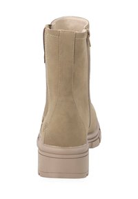 Botín de ante beige hasta el tobillo con una textura suave, cremallera lateral y una suela de plataforma baja y gruesa. Costuras simples a lo largo de los bordes.