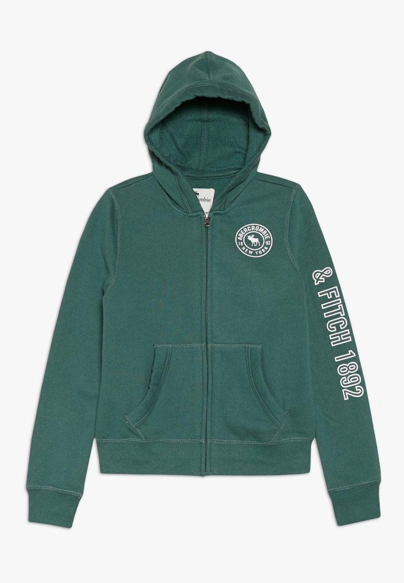 Veste à capuche zippée en mélange de coton vert foncé. Elle comporte deux poches frontales, un logo sur la poitrine et du texte blanc le long de la manche.