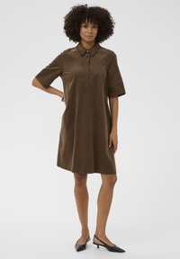 Brązowa sukienka typu shift z kołnierzykiem i krótkimi rękawami, z zapięciem na guziki i luźnym krojem dla wygody.