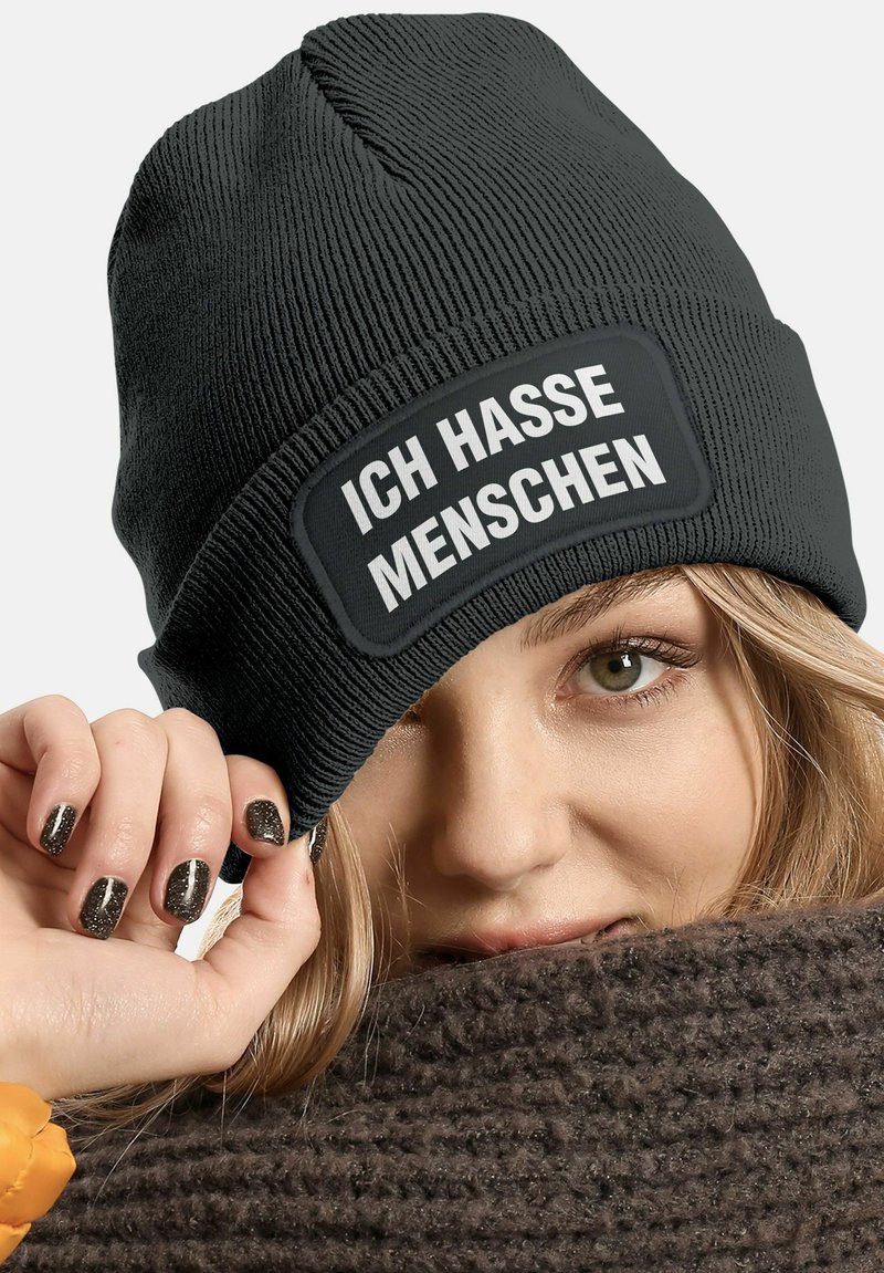 Black knitted beanie with a turn-up cuff featuring a rectangular patch with the text "ICH HASSE MENSCHEN" in white font.