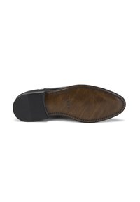 Semelle de chaussure en cuir noir avec un intérieur marron, présentant une texture antidérapante et un surfilage contrasté le long du bord. Marqué "DESA."