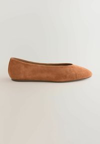 Beige Wildleder-Flatschuh mit spitzem Zehenbereich und abgerundetem Fersenbereich, der durch ein minimalistisches Design und eine glatte Textur besticht. Keine sichtbaren Beschläge oder Muster.