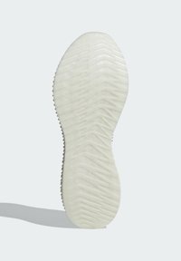 White rubber shoe sole featuring a textured, zigzag pattern with rounded edges and raised sections for traction.