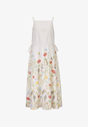 Witte mouwloze maxi-jurk met dunne bandjes en zijstrikjes, met een kleurrijke bloemenprint op de rok met rode, gele en blauwe bloemen.