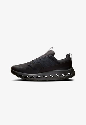 Black athletic shoes featuring a textured mesh upper, a cushioned sole with cut-out holes, and a sleek modern design.